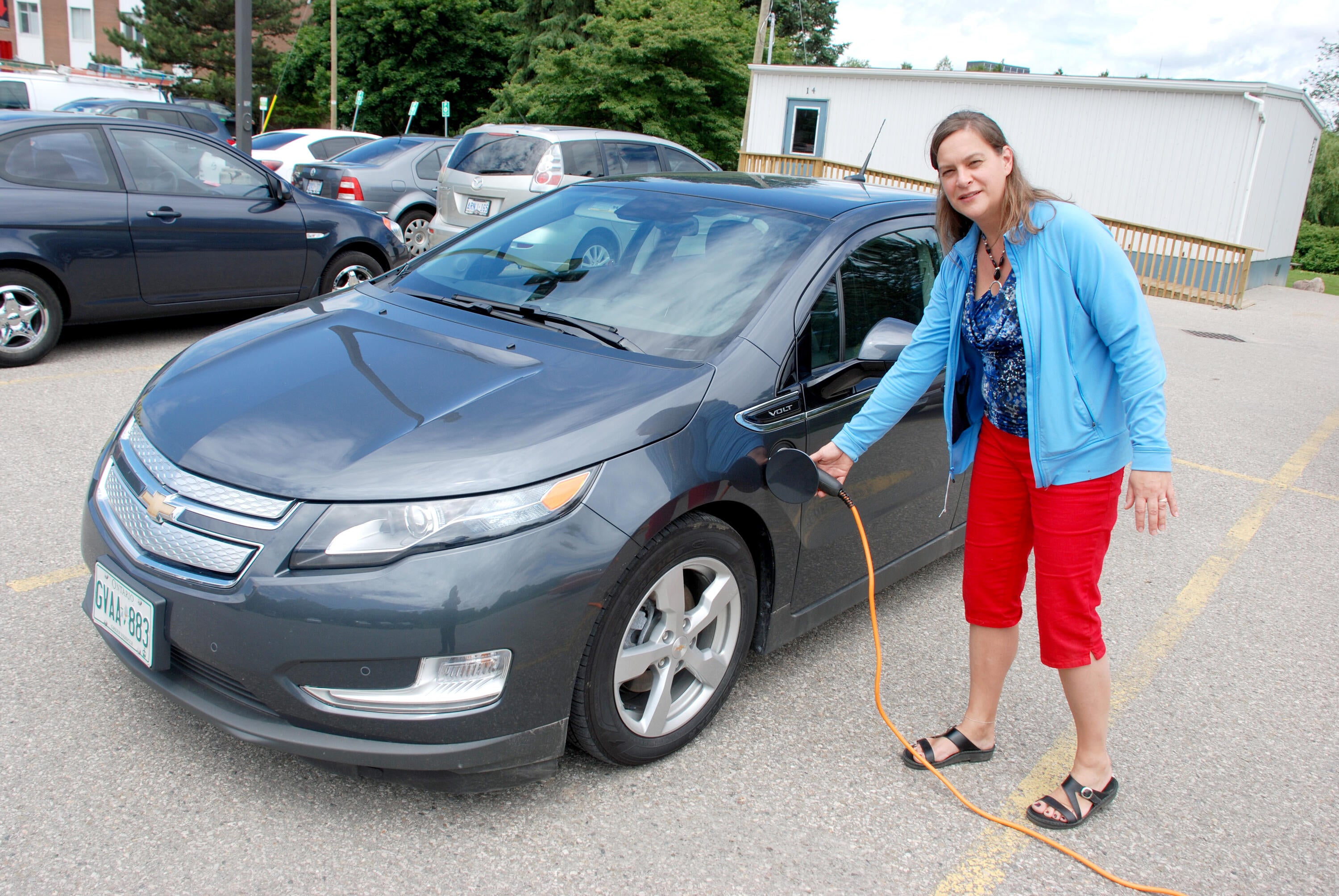 staff member with an electric car charger