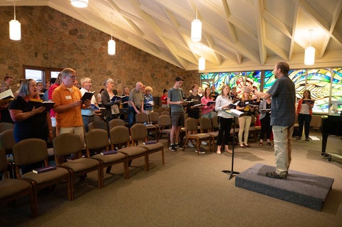 alumni singing in chapel with a conductor 
