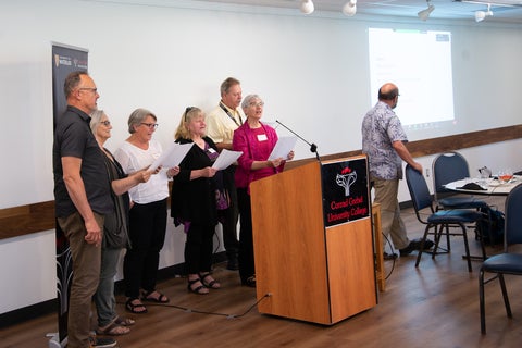 a group of alumni sing during a reunion program