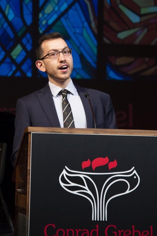 Peter Bondi wearing a suit standing at a podium 