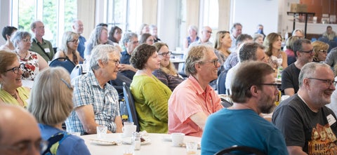 alumni gathered around tables in Cafeteria