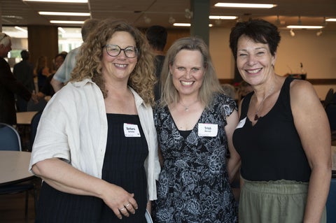 three alumni pose together