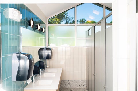 newly renovated bathroom at Grebel, sinks and stalls in a brightly lit room