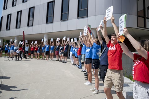 students holding welcoming signs to incoming students