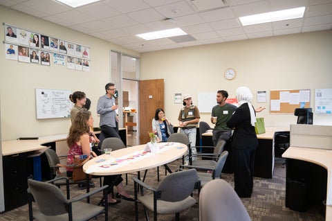 a group of people in conversation around a table in an office