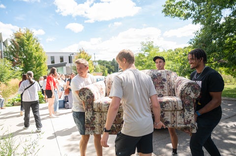 students help move a couch