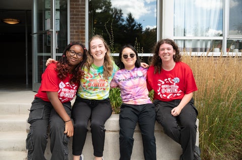 four students smiling at the camera