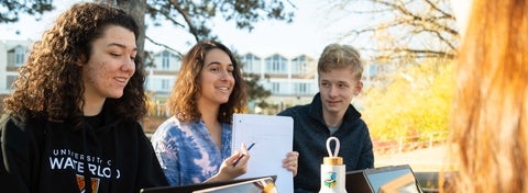3 students studying outside
