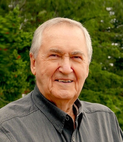 Rudy Friesen, an older gentleman wearing a grey coat, smiling.