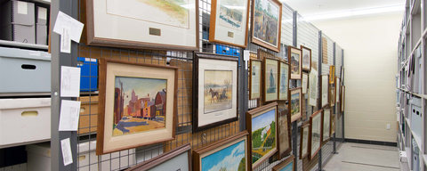 Art wall inside the archives, a grey room with old paintings and shelves