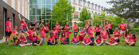 a group photo outside grebel, OMMC participants with their instruments, in red shirts.