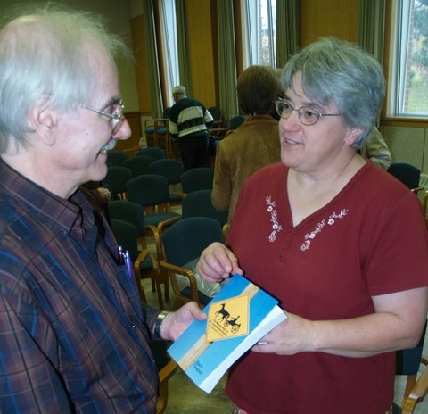 Barb Draper holding a book in front of someone 