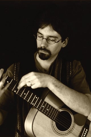 Brain Rudy holding a guitar 