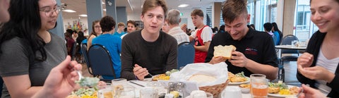 Grebel students sit around a dinner table together