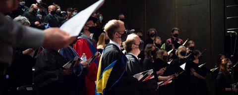 guests and professors sing during convocation 2022, in the theatre of the arts.