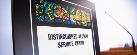 distinguished alumni award beside a podium