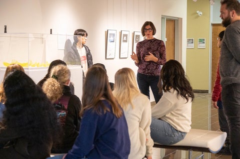 class sitting in centre for peace advancement gallery listening to a teacher
