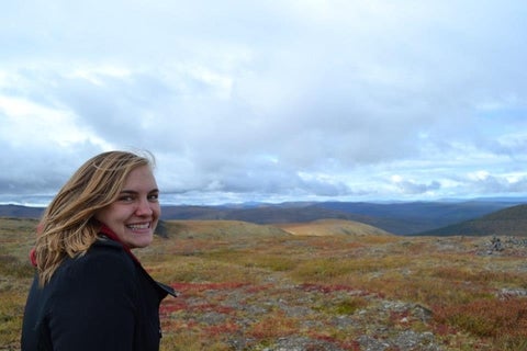 Emily Mininger looking at camera in front of valley landscape 
