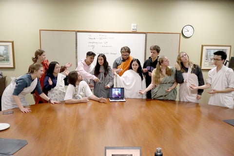 student council dressed in togas around a conference table referencing the last supper painting