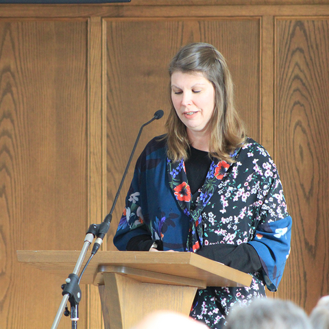 Laurel standing at a podium 