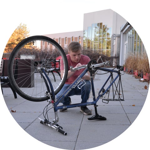 Liam fixing his bike on the grebel Patio