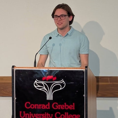 Lucas Shumaker speaking at a podium 