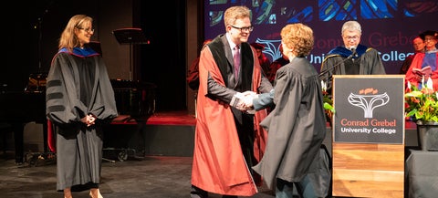 Marcus Shantz shaking hands with Graduand at Grebel convocation