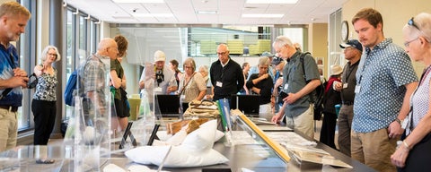A visiting group tours through a special display of archival materials in the Grebel library