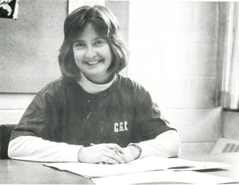 monica posing at a desk in conrad grebel sweater 