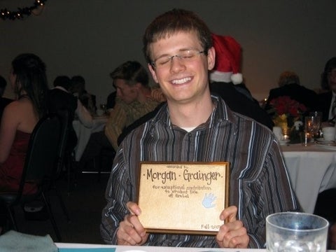 Morgan Grainger posing holding a plaque with his name inscribed 