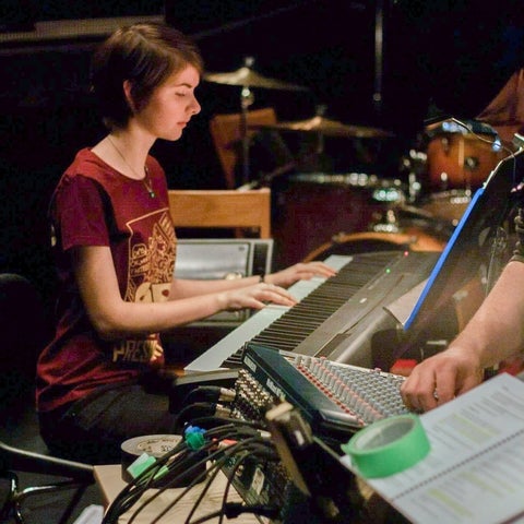 Nicole sitting at a piano 