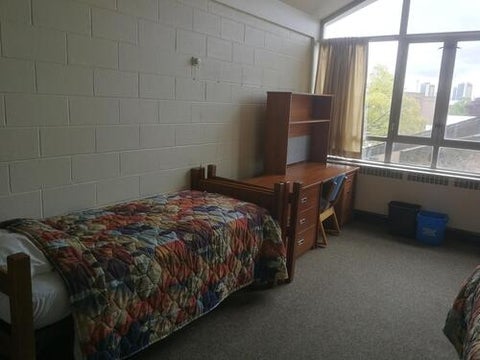 Residence room with beds, desks, and dressers