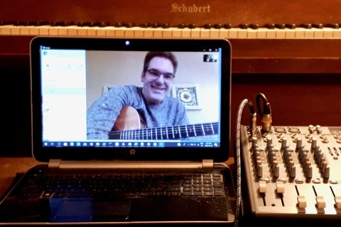 Steve holding a guitar in a computer screen 