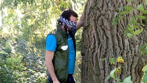 someone wearing a bandana touching a tree 