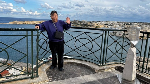 Savio Wong standing beside railing on building overlooking the mediterranean