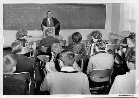 Walter Klaassen in front of classroom full of students in black and white 