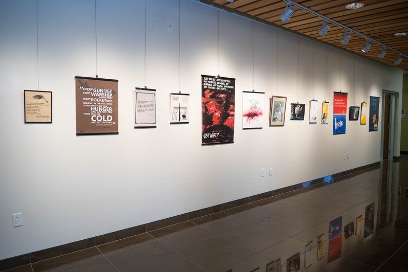 A wall of the Grebel Gallery, with serveral posters depicting peace movements.