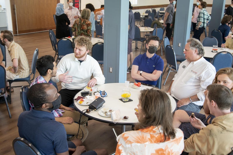 alumni sitting around a round table wearing face masks 