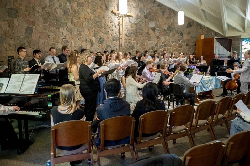 The grebel chapel full of people, a large choir and several musicians are performing