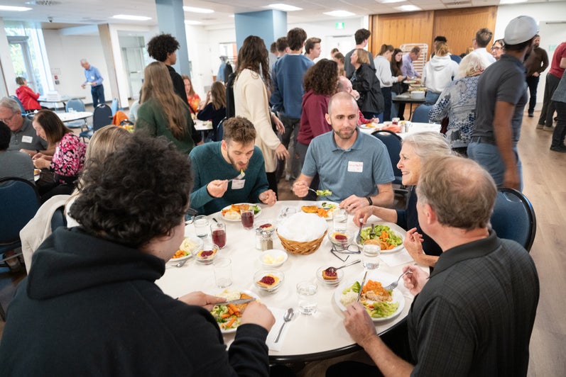 A group of Grebel alumni enjoy dinner and conversation in the dining room