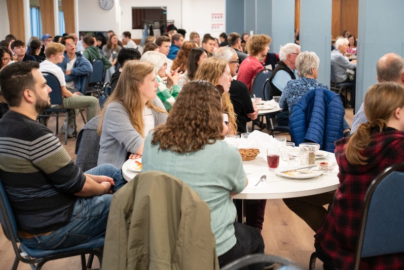 A crowd of Grebel alumni and students listen to a guest speaker