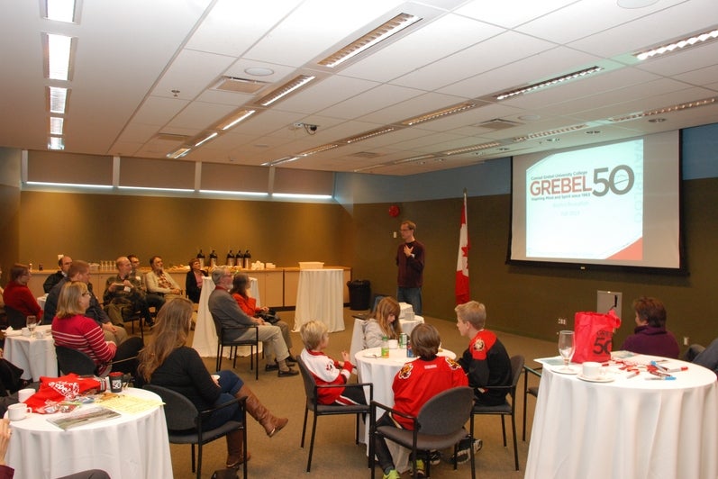 people at tables listening to speaker