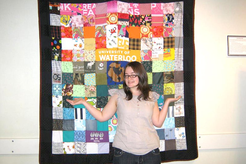 student standing in front of quilt