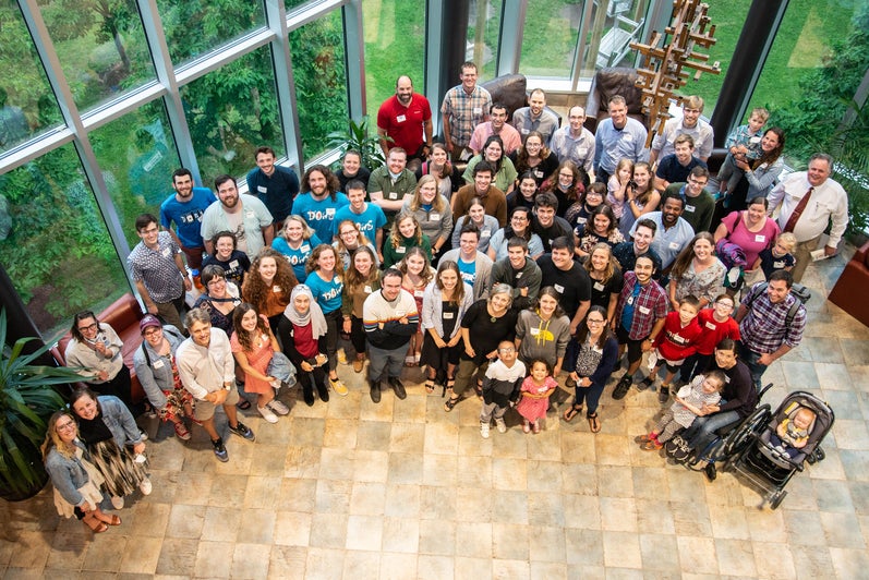 birds eye view of alumni gathered in large group looking up 