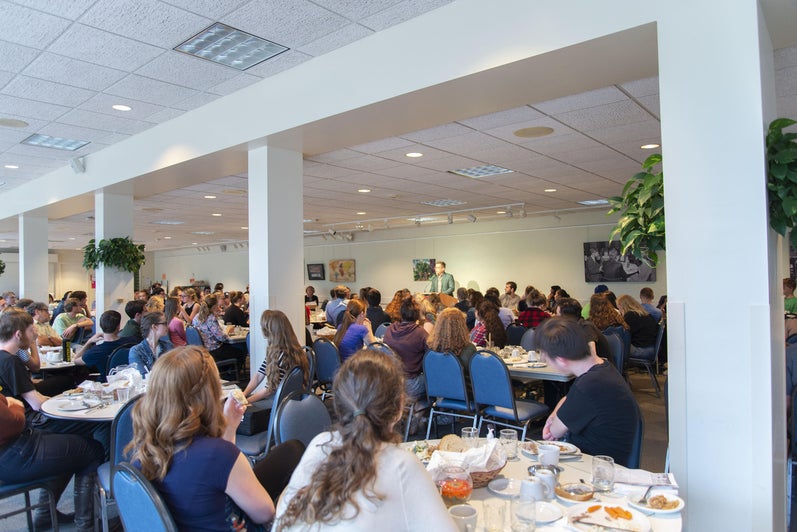 The Grebel dining room full of staff and students sitting at tables listening to Marcus speak