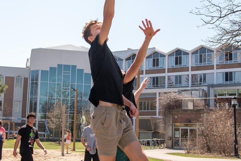 students jumping while playing basketball 