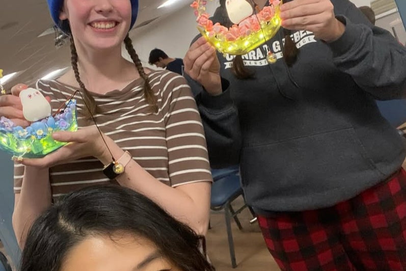 Jobina and two students holding up crafts