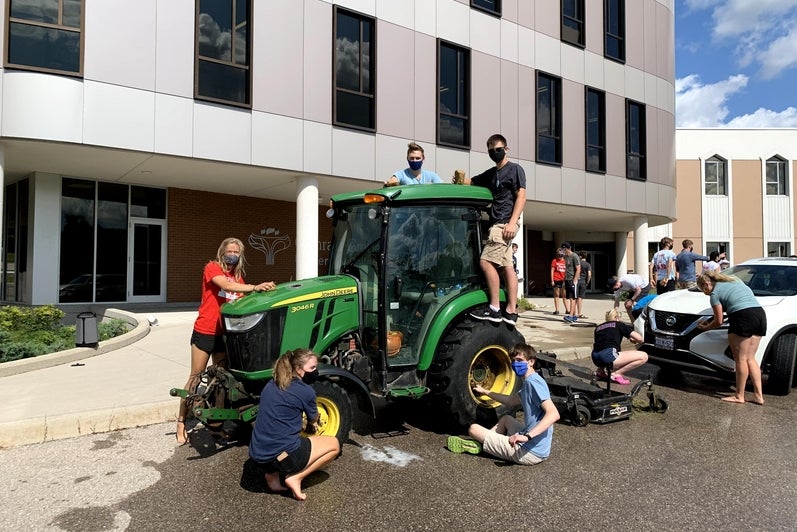 students posing with a tractor 