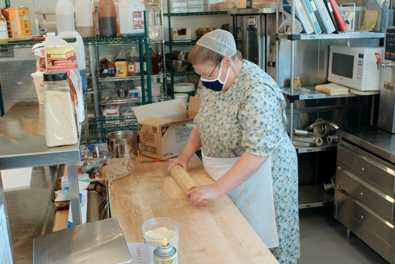 Janet rolls dough in the baking area