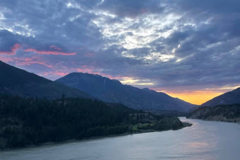 A scenic sunset over mountains and a river